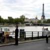 Street artist by the Seine River, painting the Eiffel Tower: Tourists casually walking by on Port de la Concorde