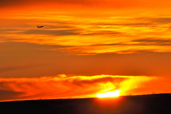 Calgary skies 01 Sunrise. Plane taking off into sun.