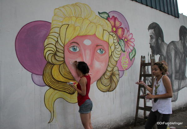 Artists creating street art on Charcarita walls.
