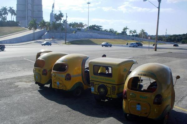 A row of coco taxis waiting to take customers on a unique ride through Havana