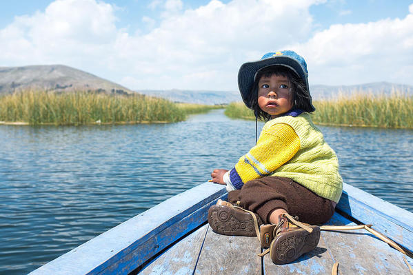 An Uro boy being transported on a boat across Lake Titicaca, courtesy Christopher Crouzet and Wikimedia