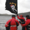 Australis crew attempting to put up a pirate flag in gale force winds off the shore of Cape Horn.