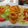 Delicious lunch of fresh calamari rings, fries and a salad
