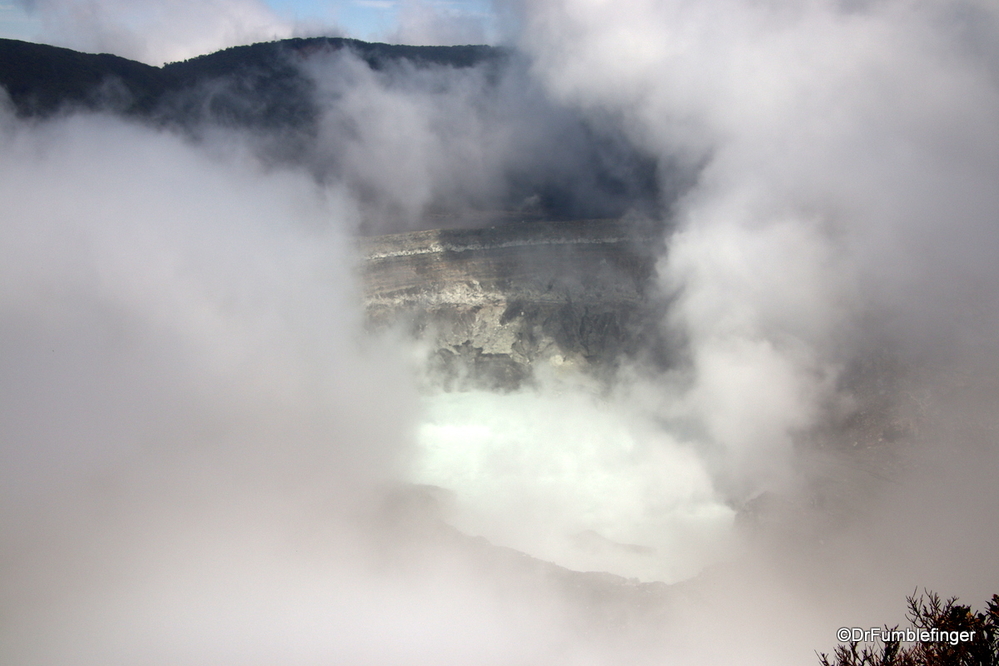 An active volcano, Poas's crater momentarily merges from the Vog