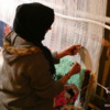Berber woman hand-weaving a carpet, Morocco